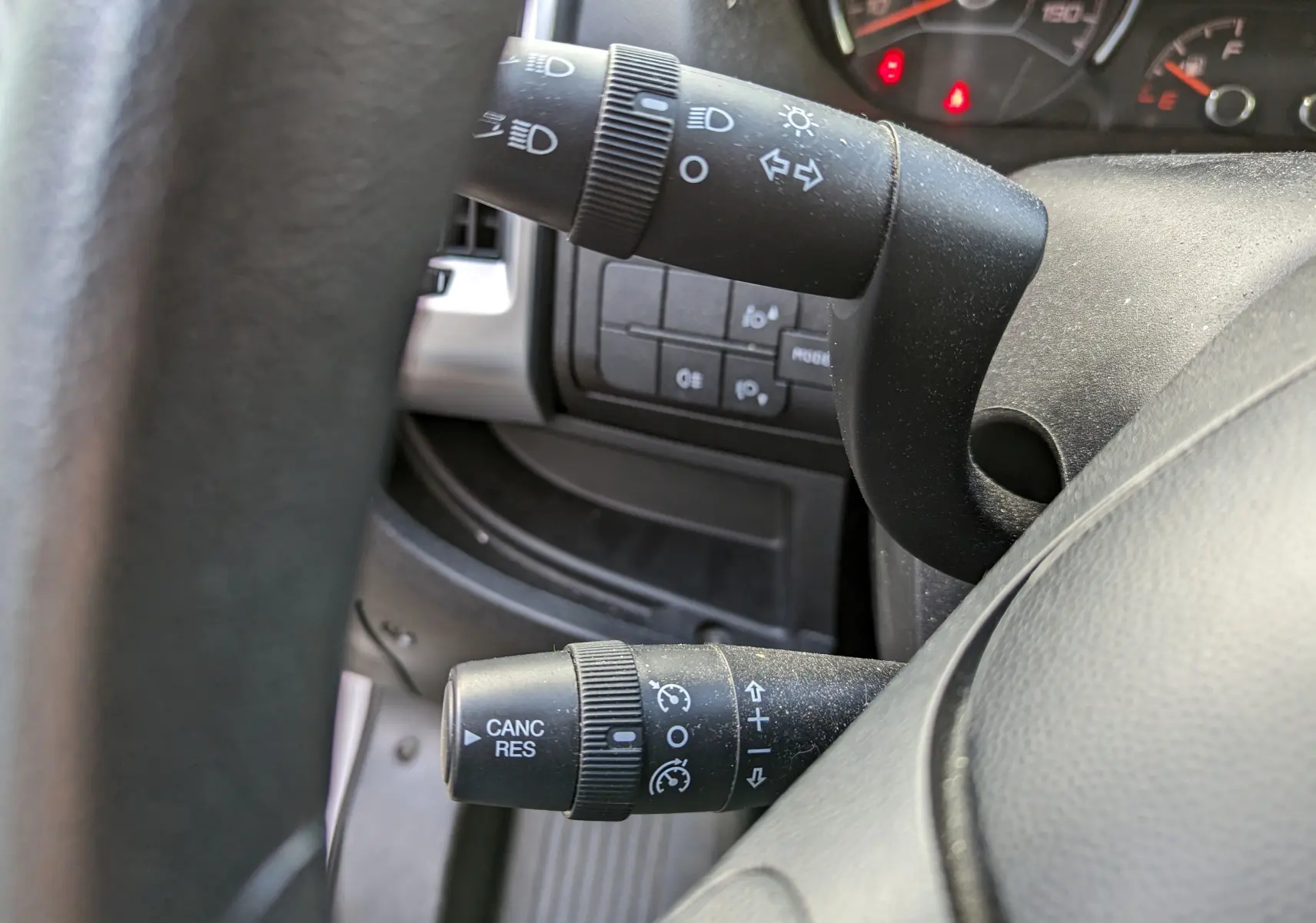 Gros plan sur les commandes de clignotants et régulateur de vitesse du tableau de bord d’un Fiat Ducato blanc de 2019.