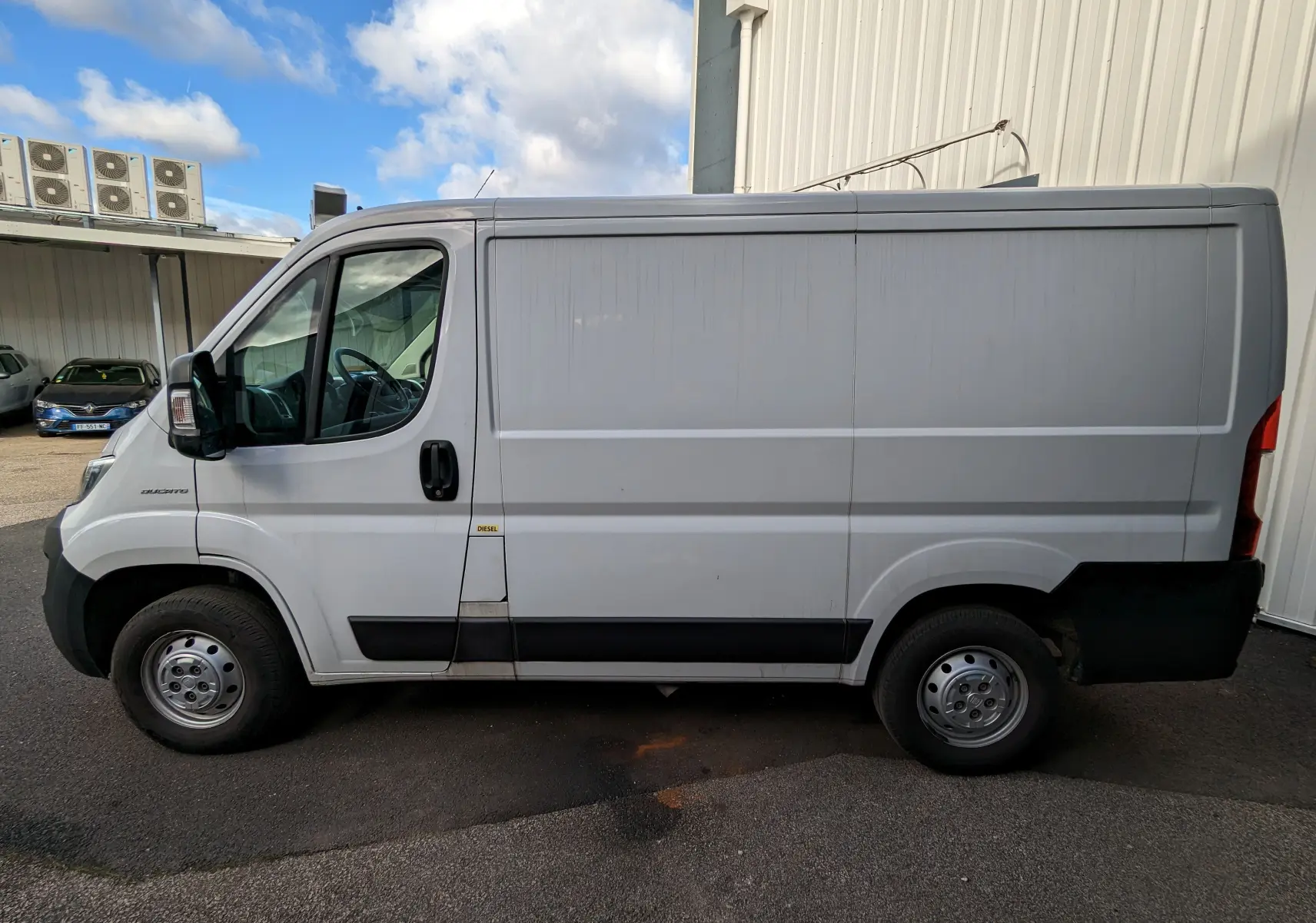 Profil côté gauche d'un FIAT Ducato Fourgon blanc de 2019, avec porte latérale coulissante et jantes acier.
