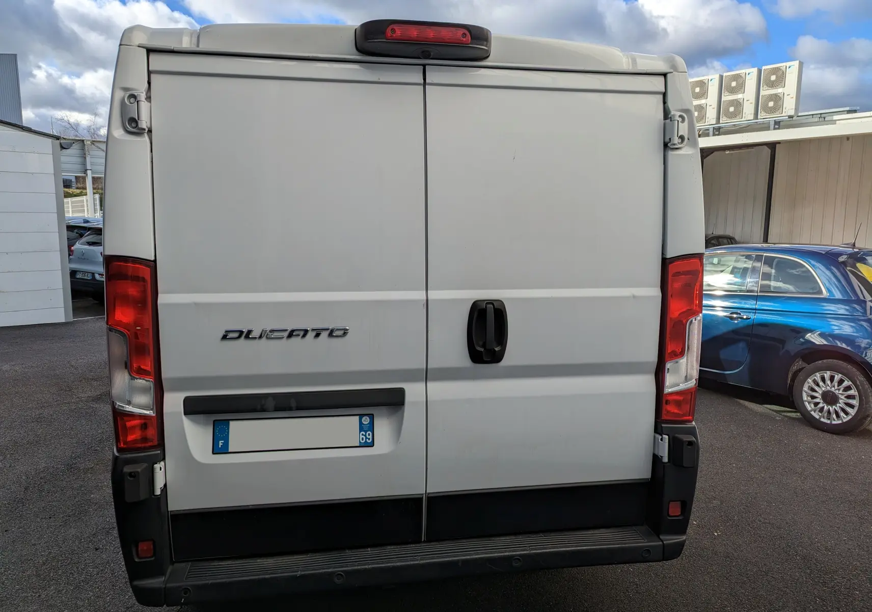 Vue arrière du fourgon blanc FIAT Ducato CH1 2.0 Multijet 115 ch avec portes battantes et feux rouges verticaux.