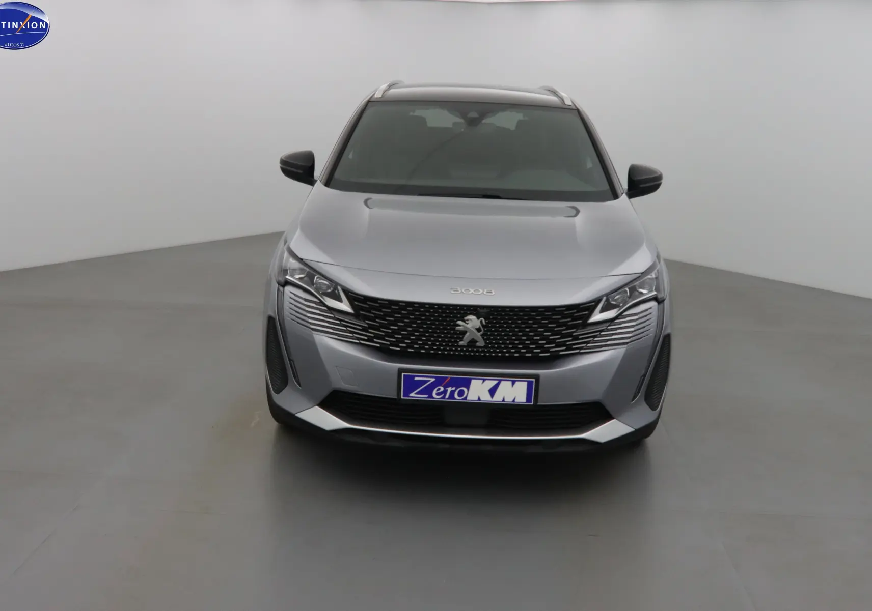Vue frontale d'un Peugeot 3008 gris Artense métal avec calandre noire et phares LED distinctifs.