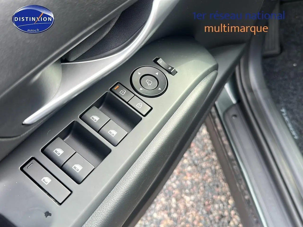 Détail des commandes des vitres et rétroviseurs côté conducteur du Hyundai Tucson vert cyprès 2025.