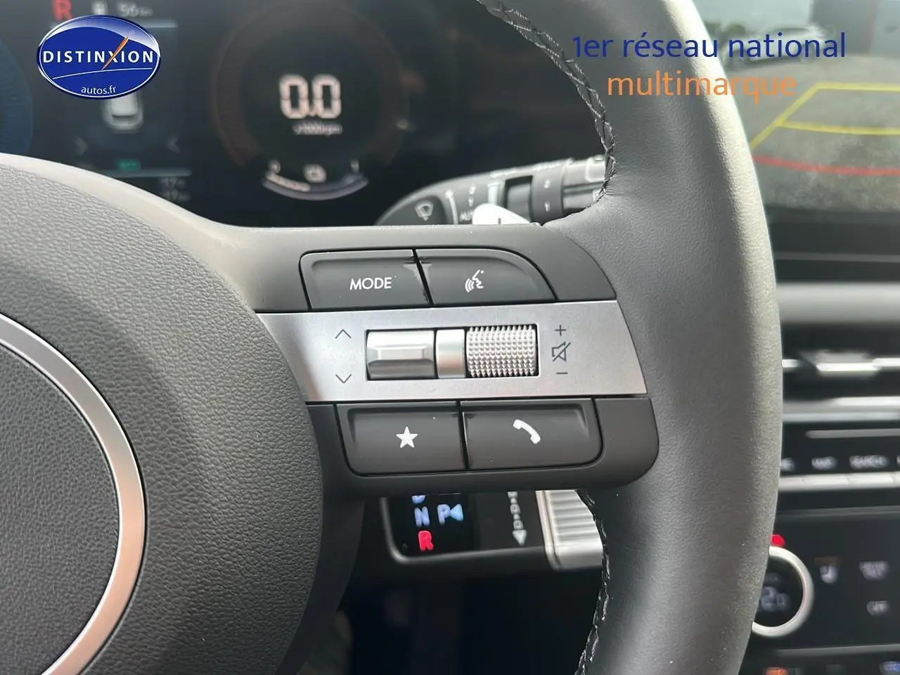 Gros plan sur le volant cuir multifonction du Hyundai Tucson 2025, avec commandes audio et affichage numérique en arrière-plan.