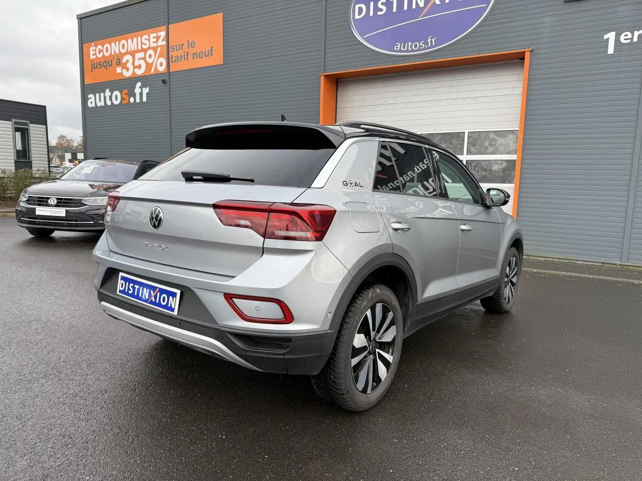 Volkswagen T-Roc argent pyrite métallisé vu en 3/4 arrière droit, avec jantes alliage et toit noir contrasté.