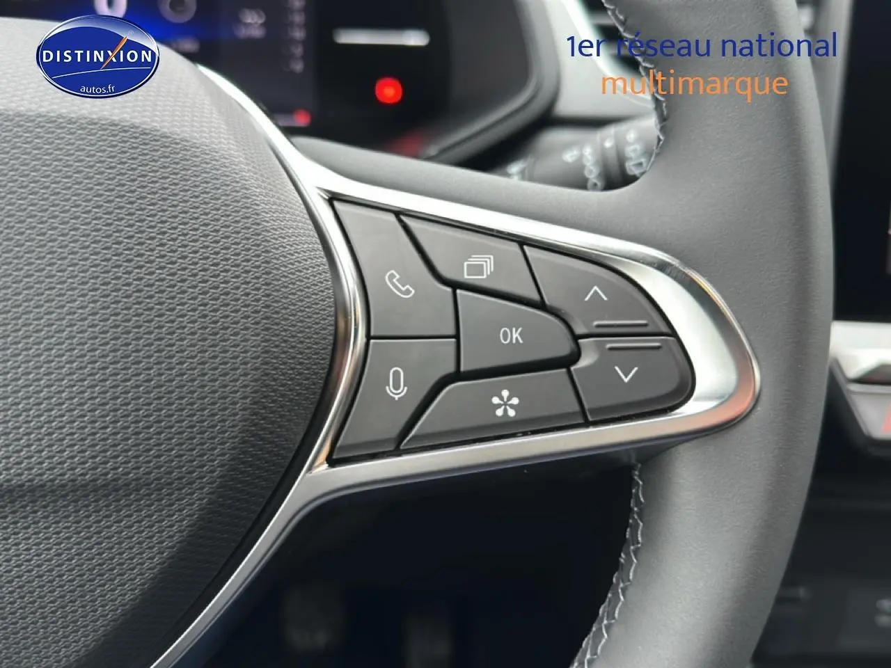 Gros plan sur les commandes multifonctions du volant du Renault Captur gris rafale, avec boutons de navigation et appel.