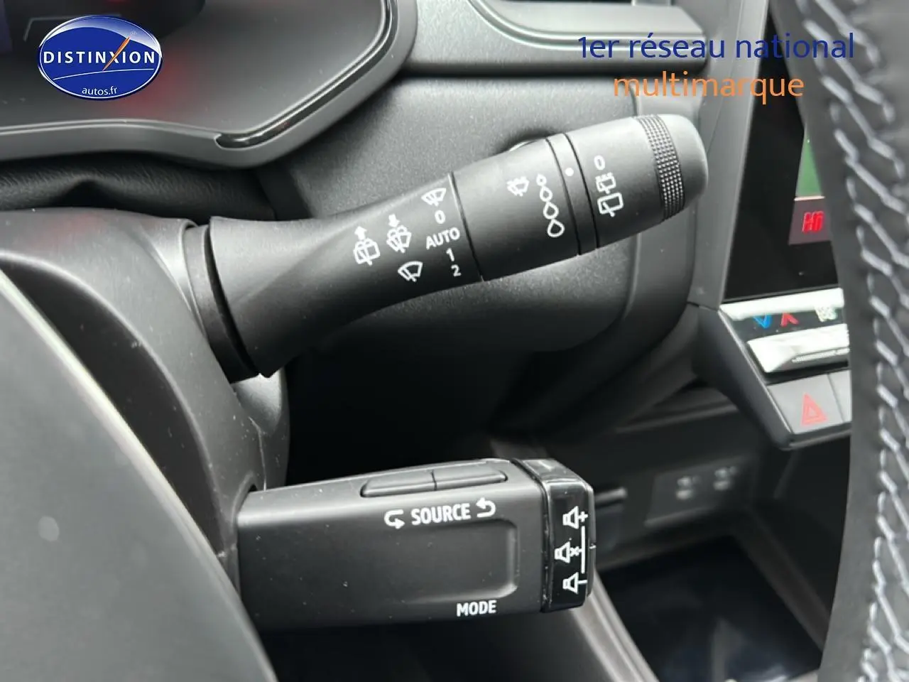 Gros plan sur les commandes au volant du Renault Captur gris rafale, mettant en valeur les fonctions source et mode.