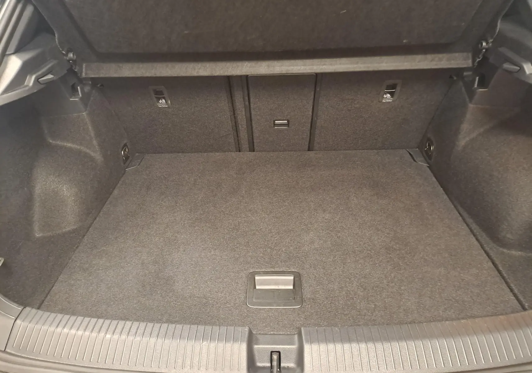 Coffre vide vu de face du Volkswagen T-Roc 2025, intérieur gris foncé avec revêtement textile.
