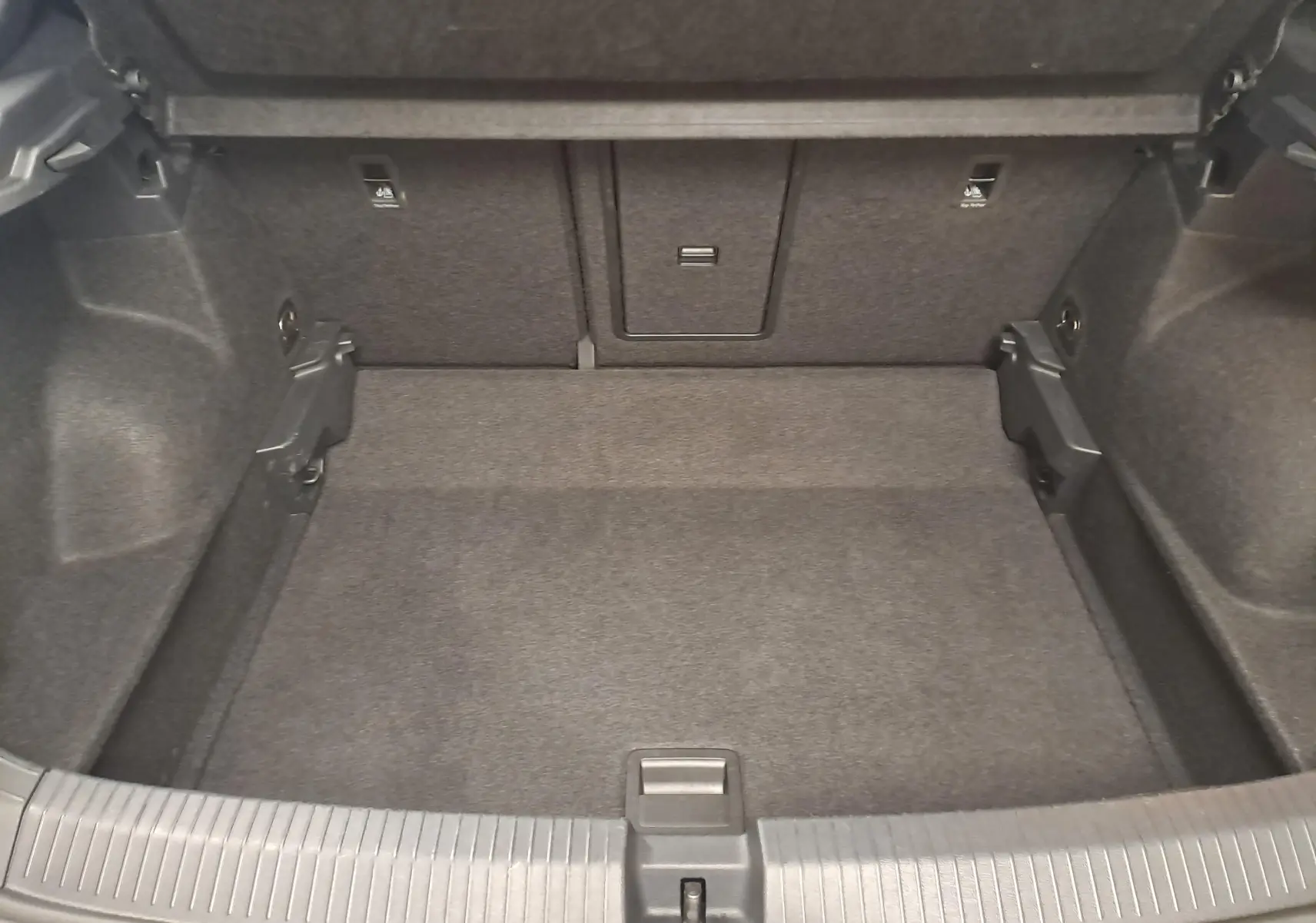 Coffre vide vu de face du Volkswagen T-Roc 2025, revêtement intérieur gris foncé, sans chargement visible.