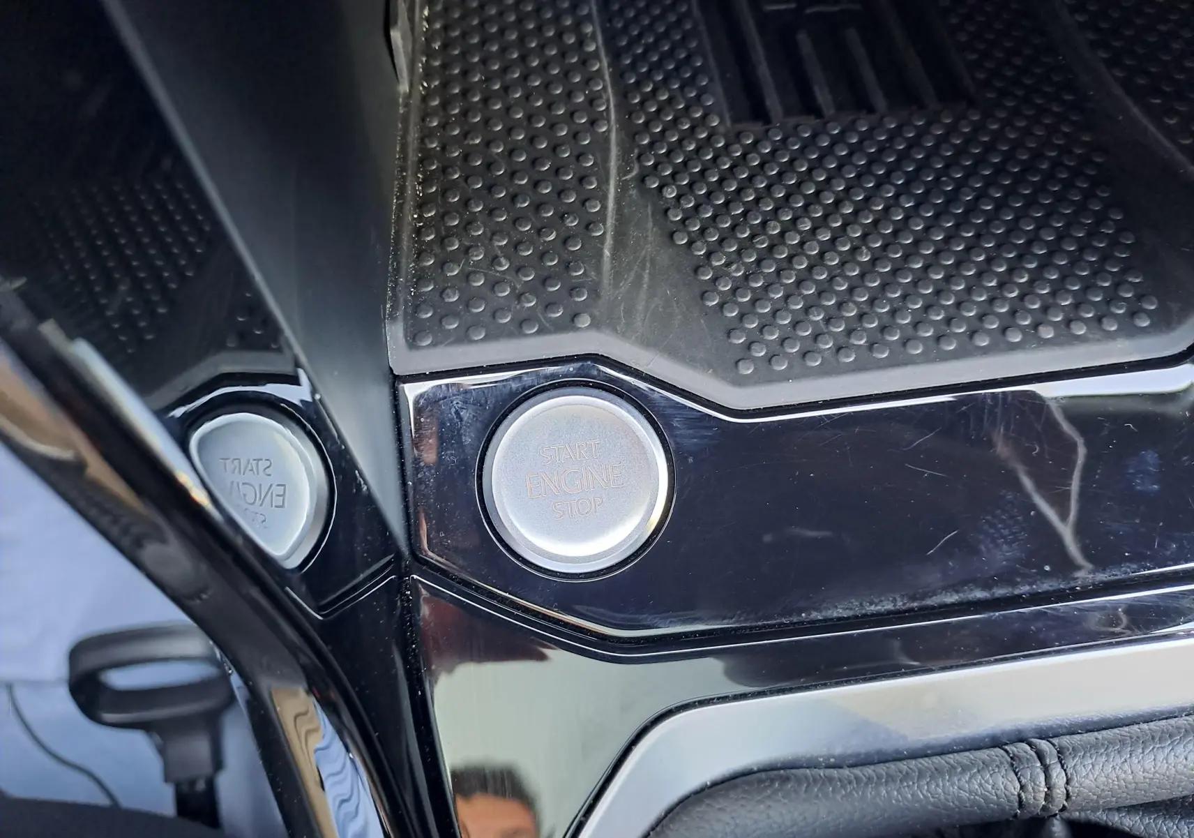 Gros plan sur le bouton Start Engine Stop au centre de la console noire brillante du Volkswagen T-Roc 2025.