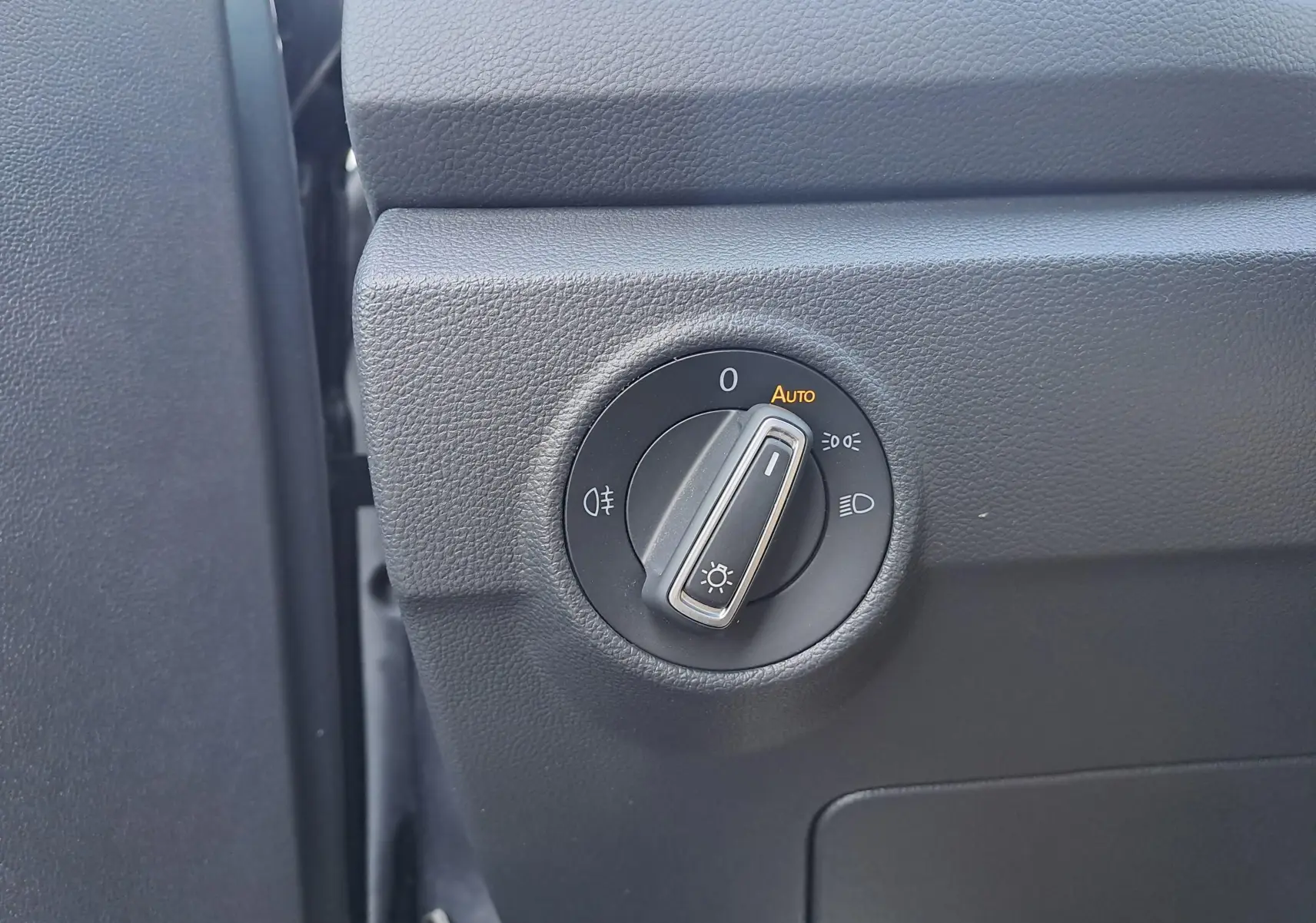 Gros plan sur le bouton de commande des phares dans l'habitacle du Volkswagen T-Roc, finition R-Line.