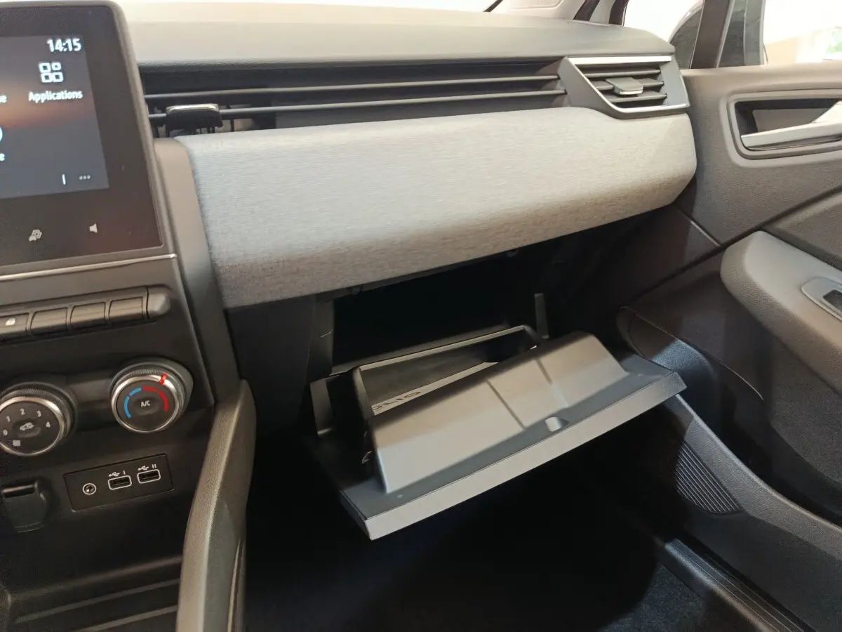 Intérieur de la Renault Clio blanc 2024, vue du tableau de bord côté passager avec boîte à gants ouverte.