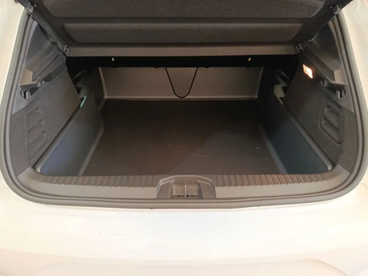 Coffre ouvert vu de l'arrière d'une Renault Clio blanche 2024, montrant un espace de chargement vide et propre.