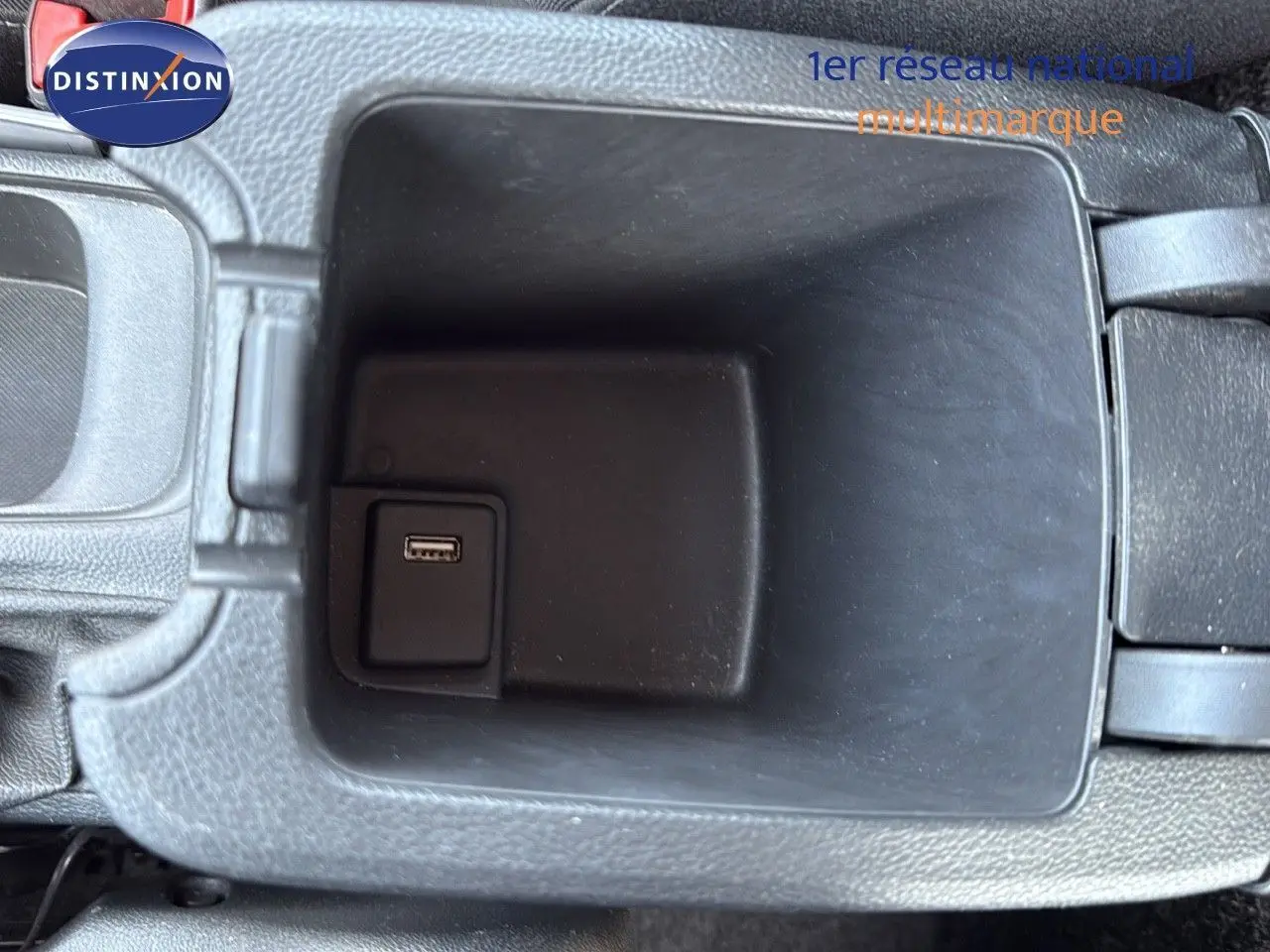 Vue rapprochée de la prise USB dans le rangement central intérieur de l’Opel Astra Sports Tourer gris minéral métal.