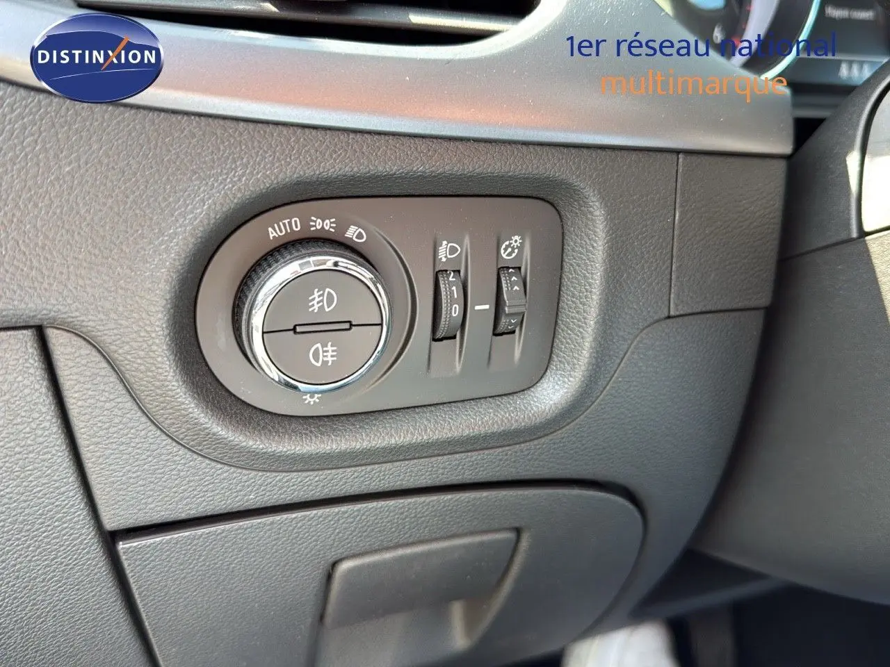 Gros plan sur les commandes d'éclairage à gauche du volant dans l'habitacle gris foncé de l'Opel Astra Sports Tourer 2021.