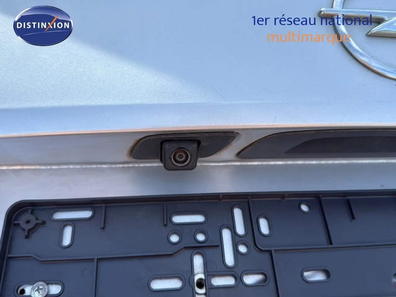 Gros plan sur la caméra de recul et la plaque d'immatriculation arrière d'une Opel Astra Sports Tourer gris minéral métal.