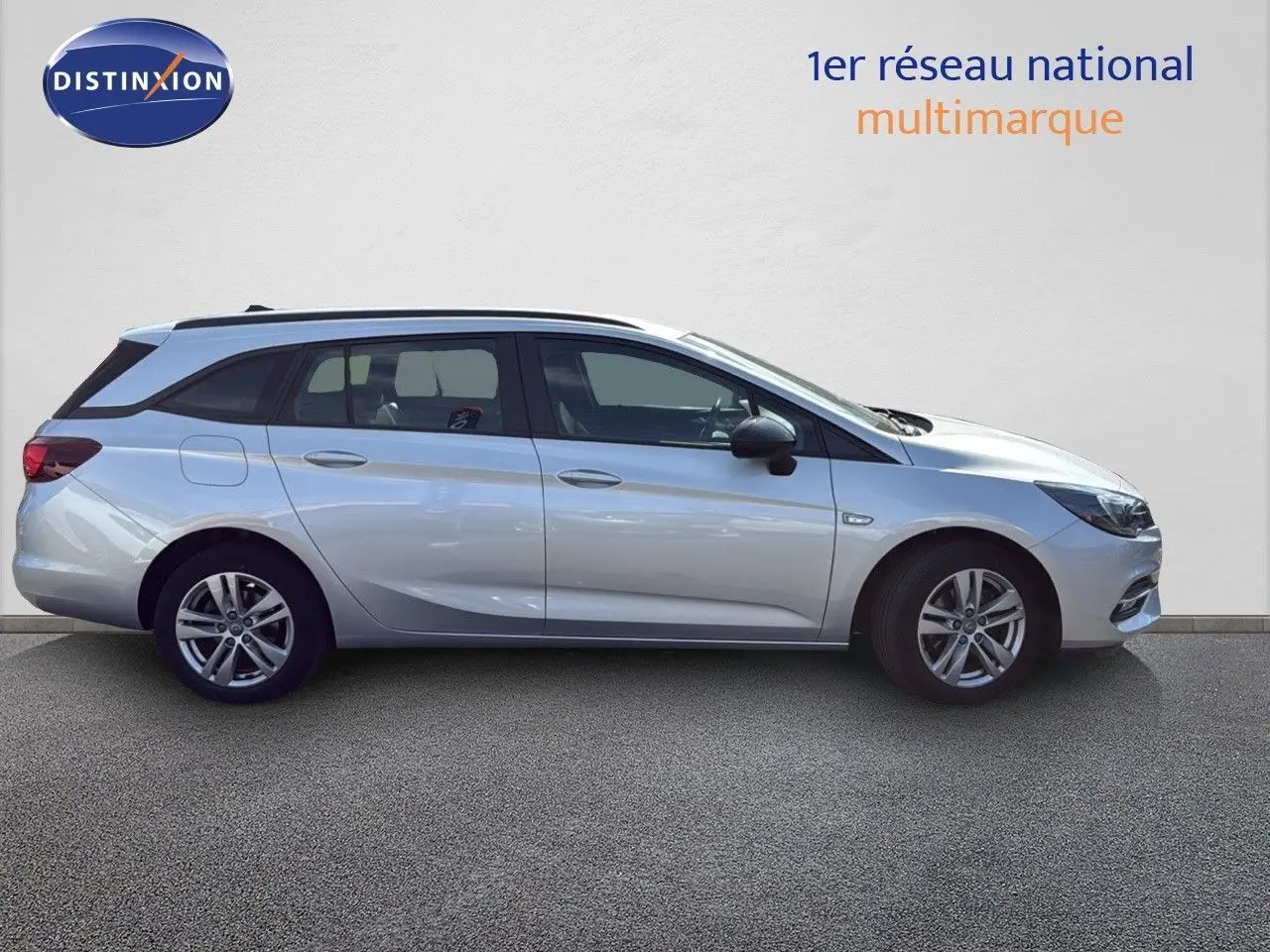 Opel Astra Sports Tourer gris minéral métal vue de profil côté gauche sur fond neutre, mettant en valeur ses lignes fluides.