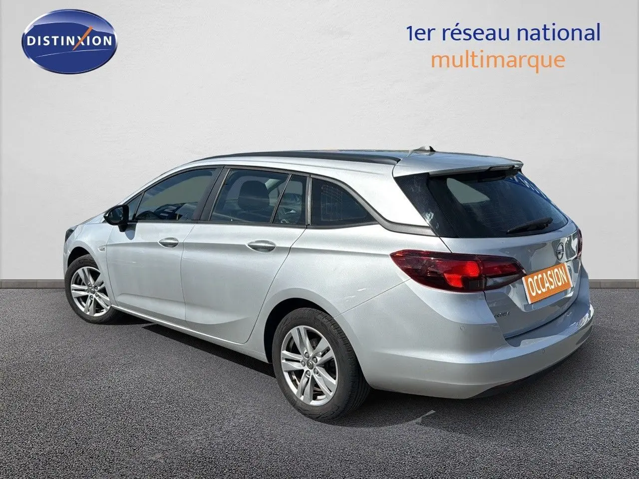 Opel Astra Sports Tourer gris minéral métal vue 3/4 arrière côté droit avec feux arrière LED et jantes alliage.