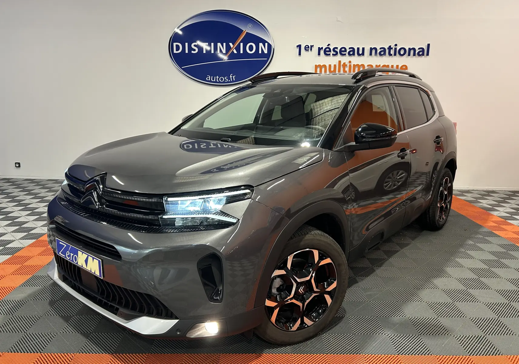 Citroën C5 Aircross gris platinium en 3/4 avant droit, avec jantes bicolores et feux LED allumés.