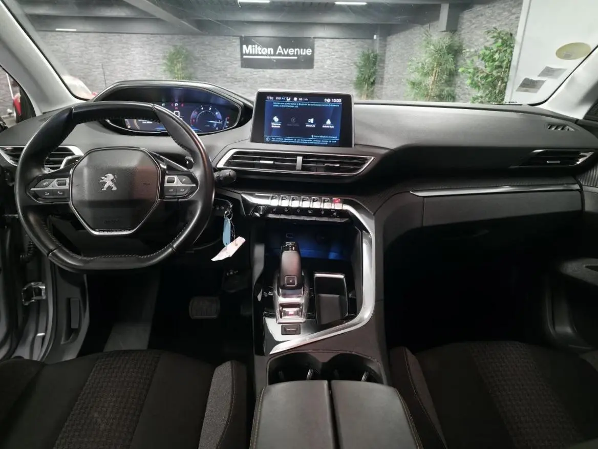 Intérieur Peugeot 5008 2020 vu de face, volant compact cuir, écran tactile 8 pouces et console centrale moderne noire.
