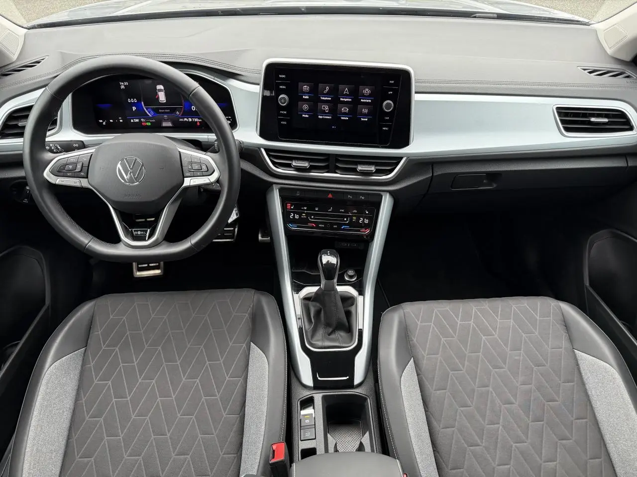 Vue intérieure frontale du Volkswagen T-Roc 2025, tableau de bord moderne avec écran tactile et volant multifonction noir.
