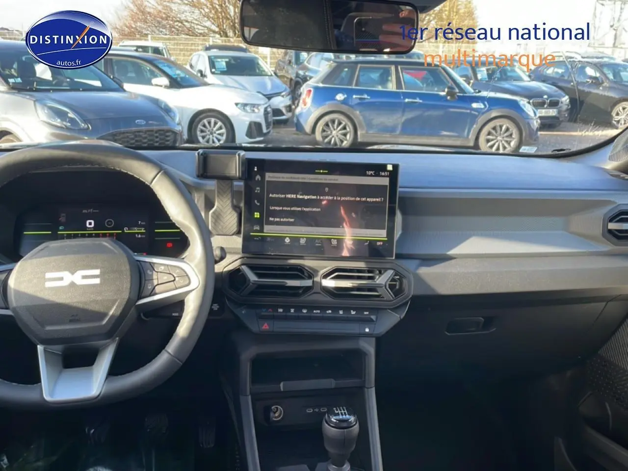 Vue intérieure du tableau de bord du Dacia Duster noir 2026, avec écran tactile central et volant multifonction.