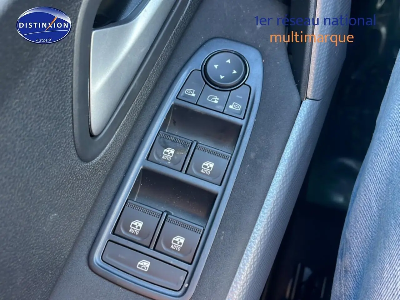 Gros plan sur les commandes des vitres électriques côté gauche d’un Dacia Duster noir 2026.