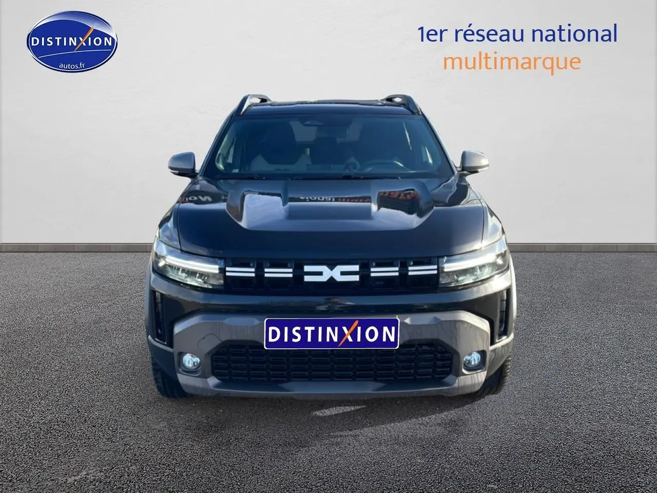 Vue frontale du Dacia Duster noir 2026 avec calandre distinctive et phares LED allumés.