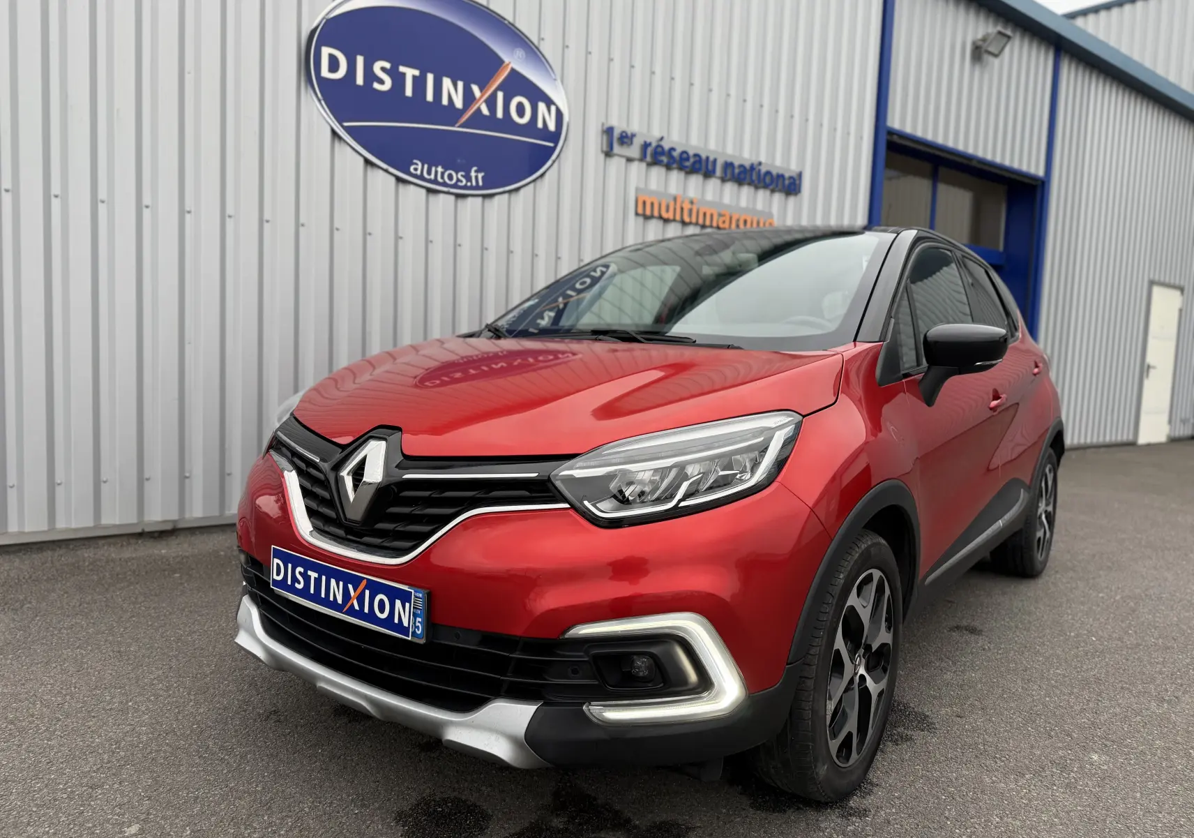 Renault Captur rouge en 3/4 avant droit, avec signature lumineuse LED et calandre noire brillante.