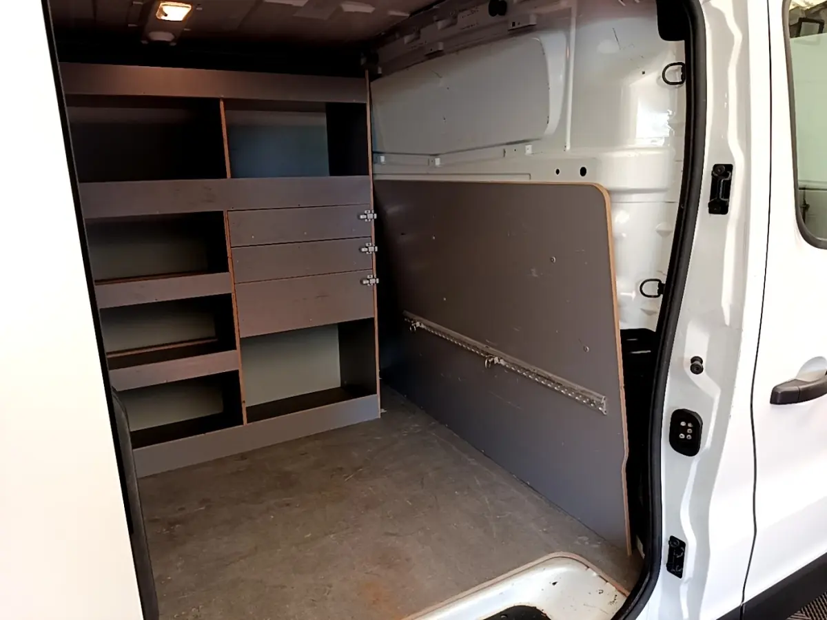 Vue intérieure côté droit du Renault Trafic Fourgon blanc 2021, montrant les étagères de rangement et l'espace de chargement.