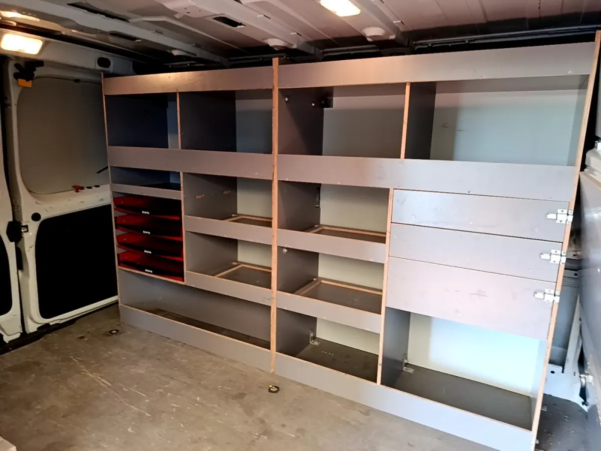 Vue intérieure du Renault Trafic Fourgon blanc 2021, montrant les étagères de rangement côté droit du compartiment de chargement.