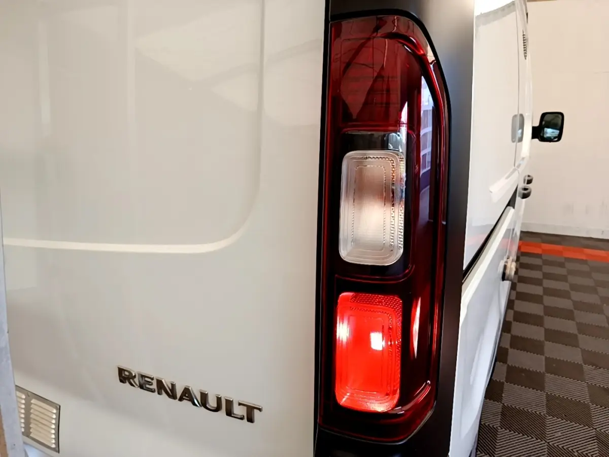 Gros plan sur le feu arrière droit et le logo Renault d’un fourgon blanc Renault Trafic L1H1 2021, vue arrière côté droit.