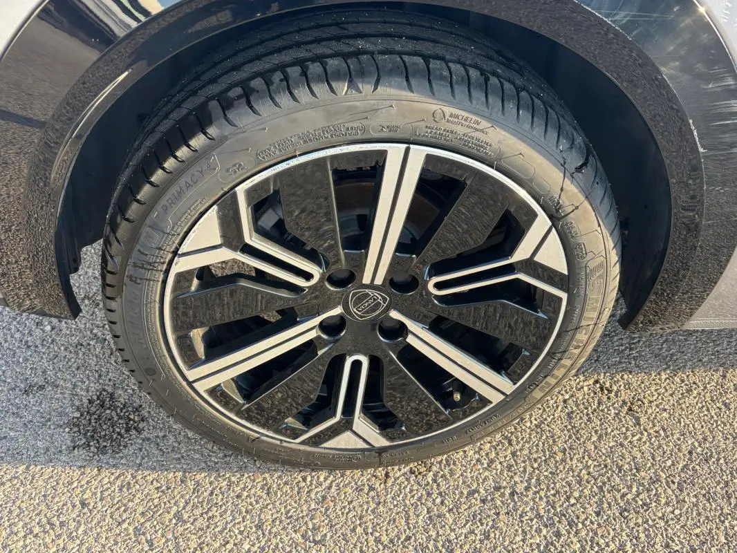 Gros plan sur la jante avant droite 17 pouces noire et argentée d'une Lancia Ypsilon gris 2025.