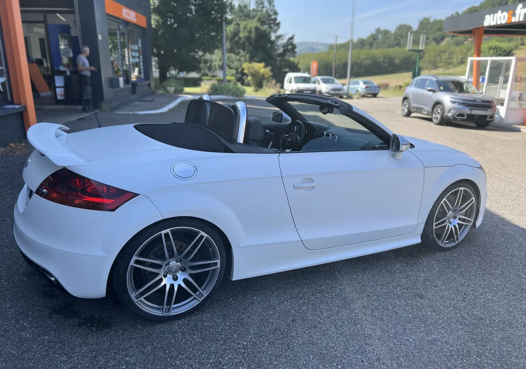 Audi TT RS Roadster blanc vue de côté droit avec capote ouverte et aileron arrière distinctif