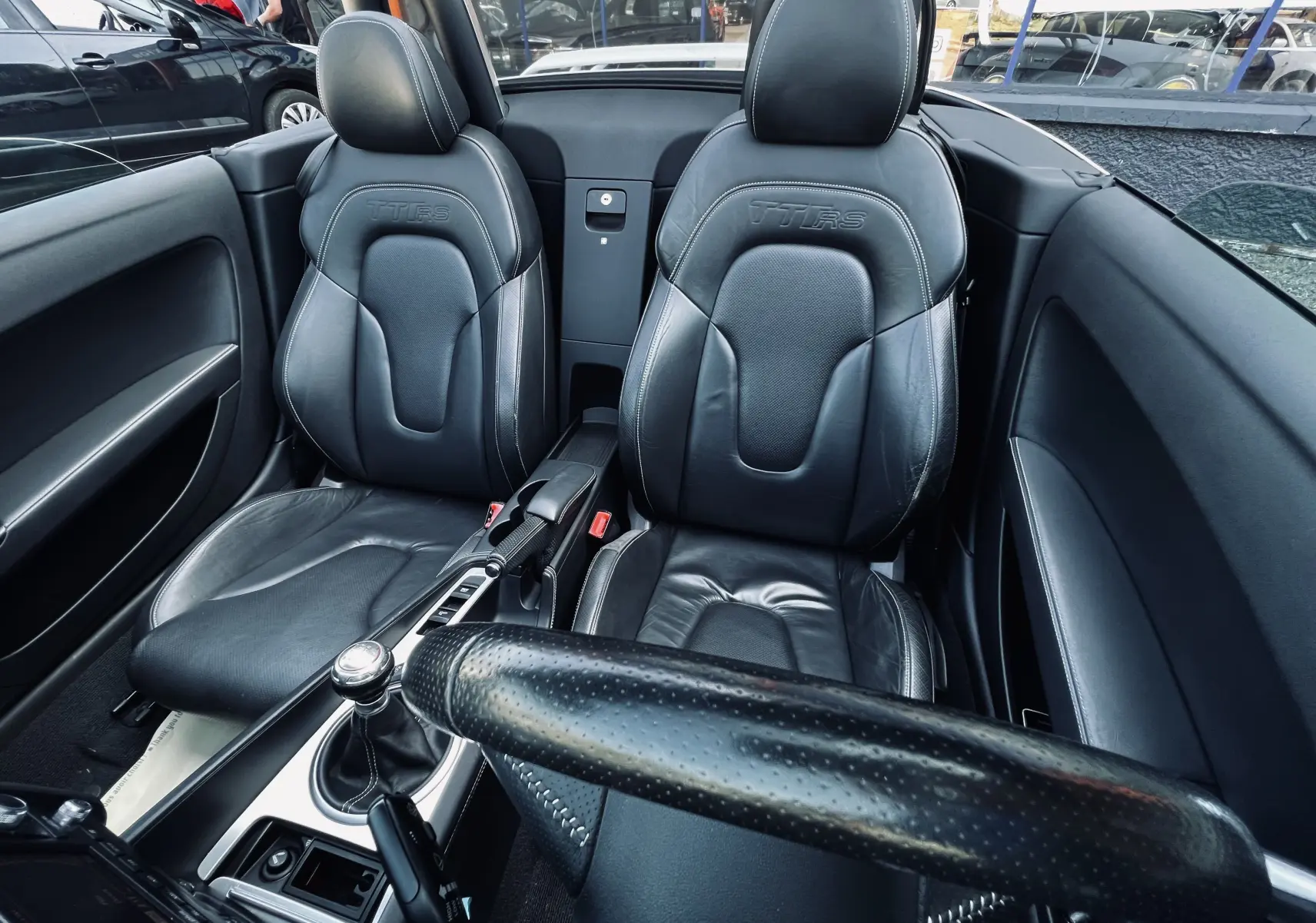 Intérieur noir en cuir de l'Audi TT RS Roadster 2009, vue rapprochée des sièges baquets et levier de vitesse manuel.