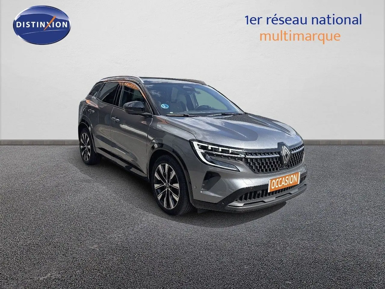Renault Austral gris schiste métal en 3/4 avant droit, avec calandre distinctive et jantes alliage bicolores.