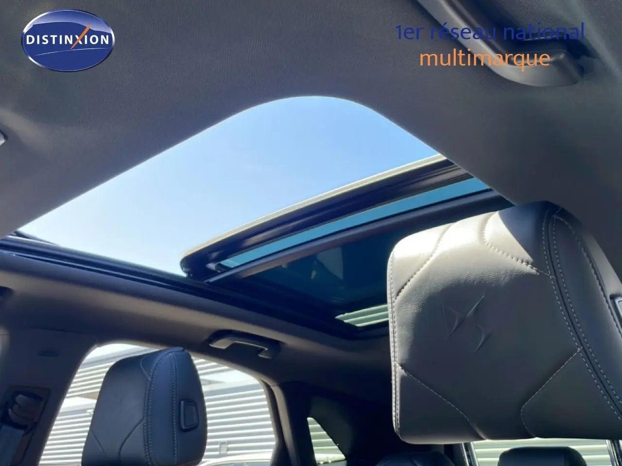 Vue intérieure du toit ouvrant panoramique et appuie-tête en cuir noir du DS7 BlueHDi 130ch Opera 2024.