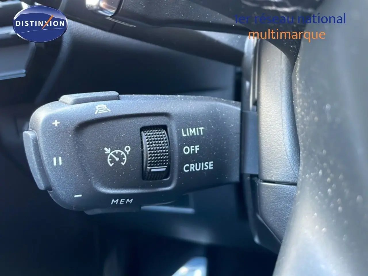 Gros plan sur la commande de régulateur de vitesse à gauche du volant d’un DS7 noir métal 2024.