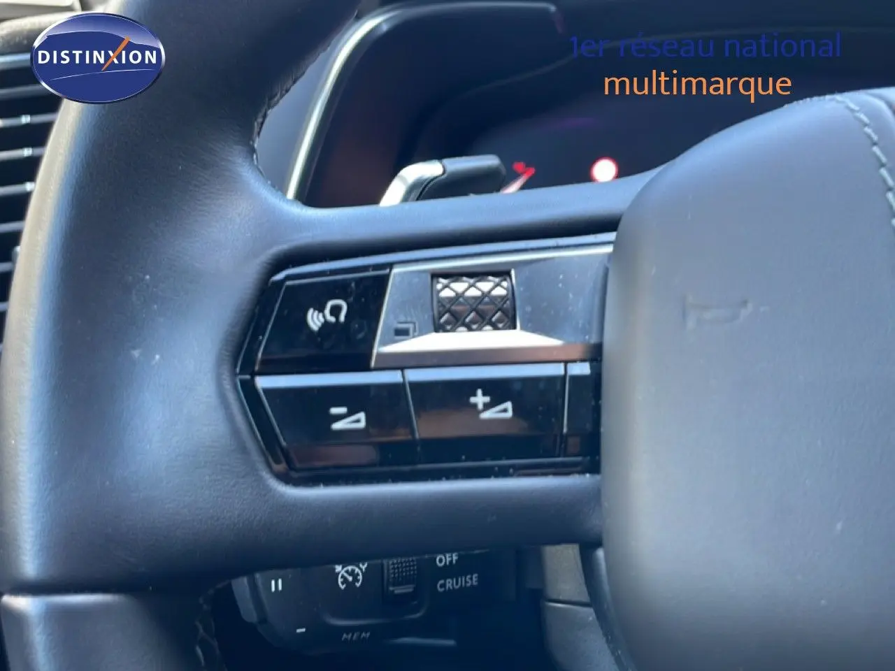 Gros plan sur le volant noir du DS7 2024, mettant en valeur les commandes intégrées côté gauche.