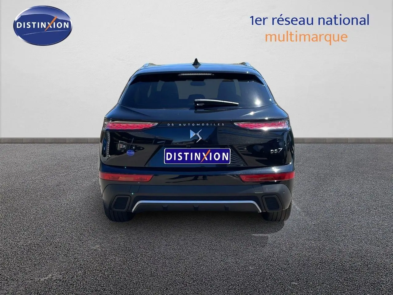 Vue arrière d'un DS7 noir métal 2024 avec feux LED effilés et logo DS centré sur un fond clair.