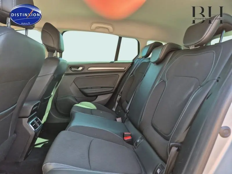 Vue intérieure arrière côté droit de la Renault Mégane Break 2024 avec sièges tissu gris foncé et appuie-têtes réglables.