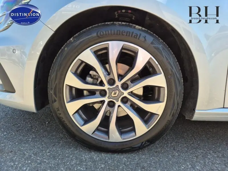 Gros plan sur la jante alu et le pneu Continental du côté avant gauche d'une Renault Mégane Break gris Titanium 2024.