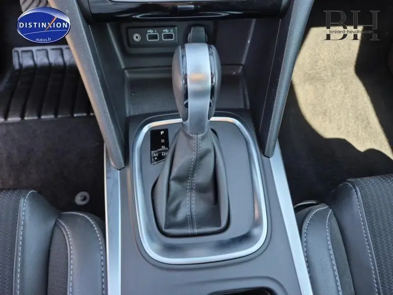 Gros plan sur la commande de boîte automatique de la Renault Mégane Break 2024, intérieur noir et gris.