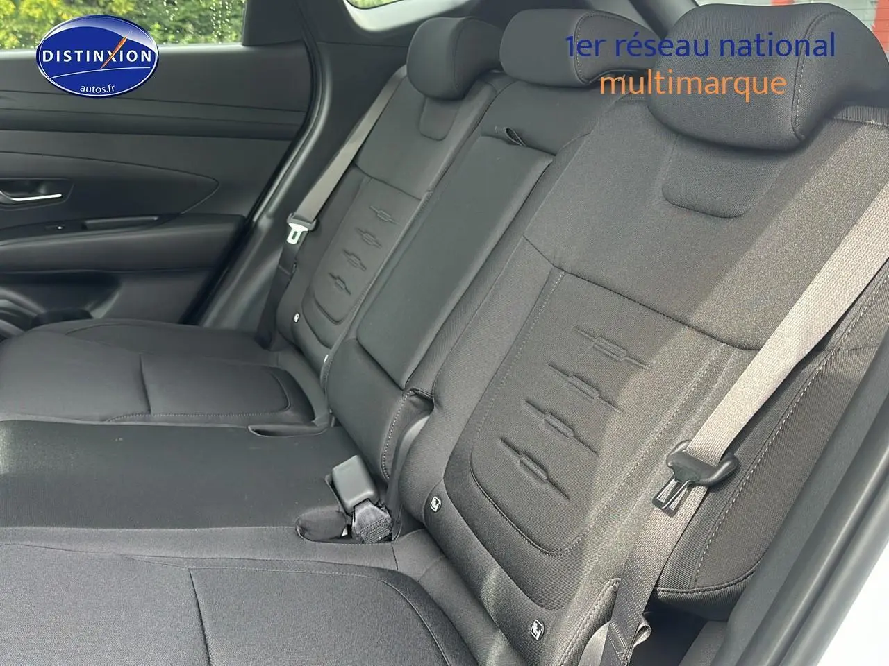 Vue latérale droite de la banquette arrière noire du Hyundai Tucson 2025 blanc Sérénité avec ceinture de sécurité visible.