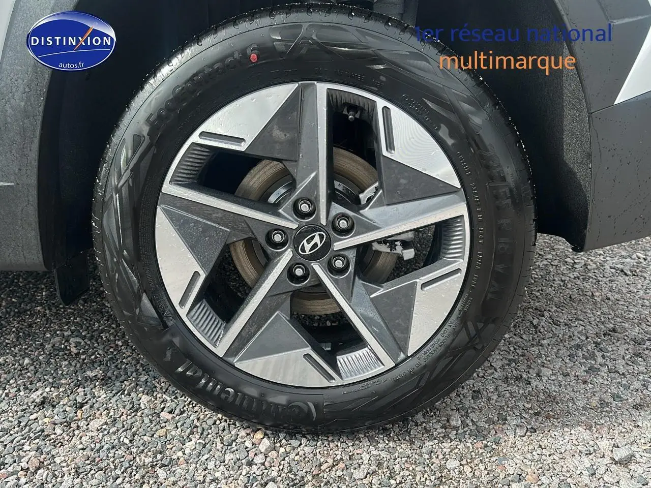 Gros plan sur la jante avant droite en alliage du Hyundai Tucson blanc Sérénité 2025 avec logo Hyundai central.