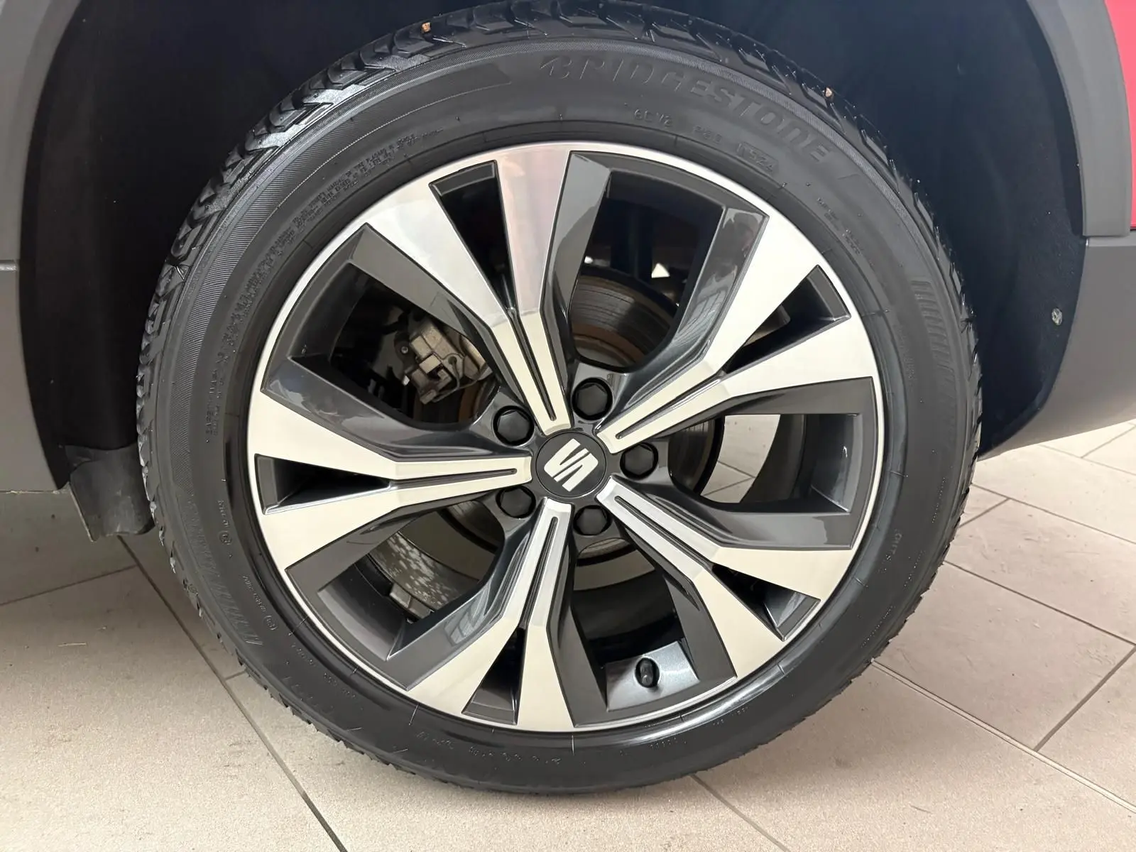 Gros plan sur la jante alliage bicolore du SEAT Ateca Rouge Velvet, vue côté droit, soulignant le design moderne.