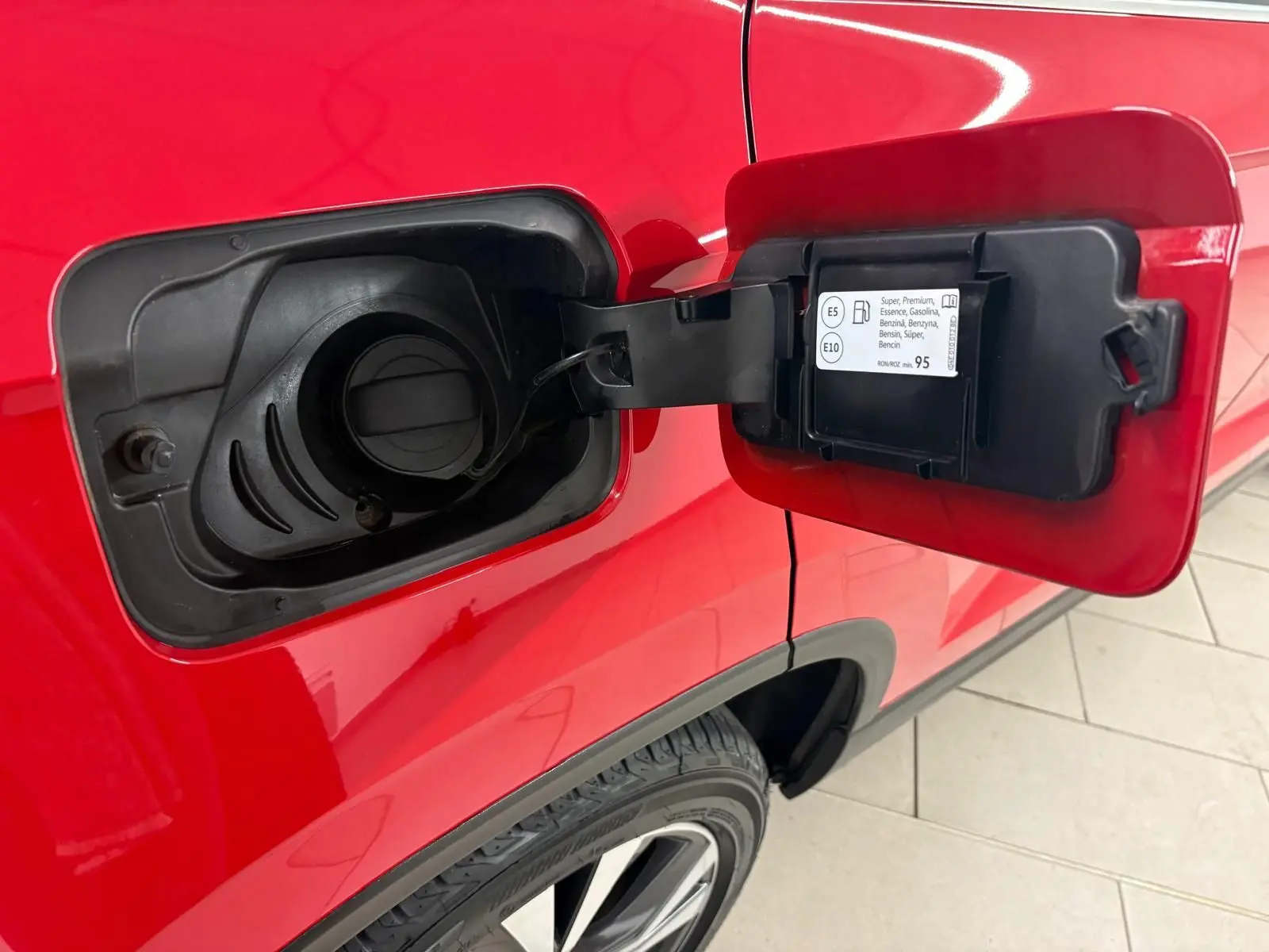 Détail de la trappe à carburant ouverte côté gauche d’un SEAT Ateca Rouge Velvet 2024 avec peinture métallisée.