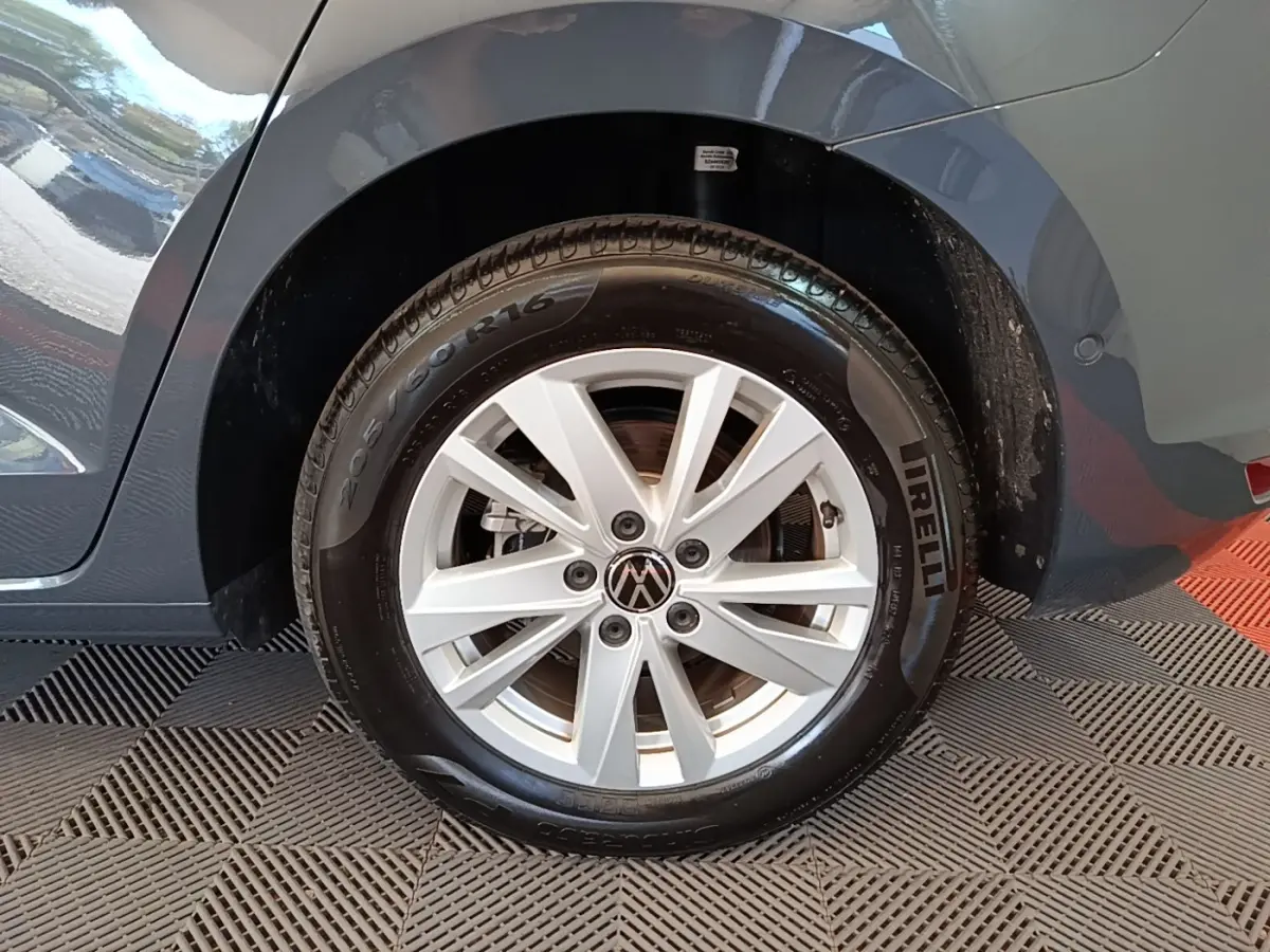 Gros plan sur la roue arrière droite d’un Volkswagen Touran gris clair, jante alliage et pneu Pirelli visible.