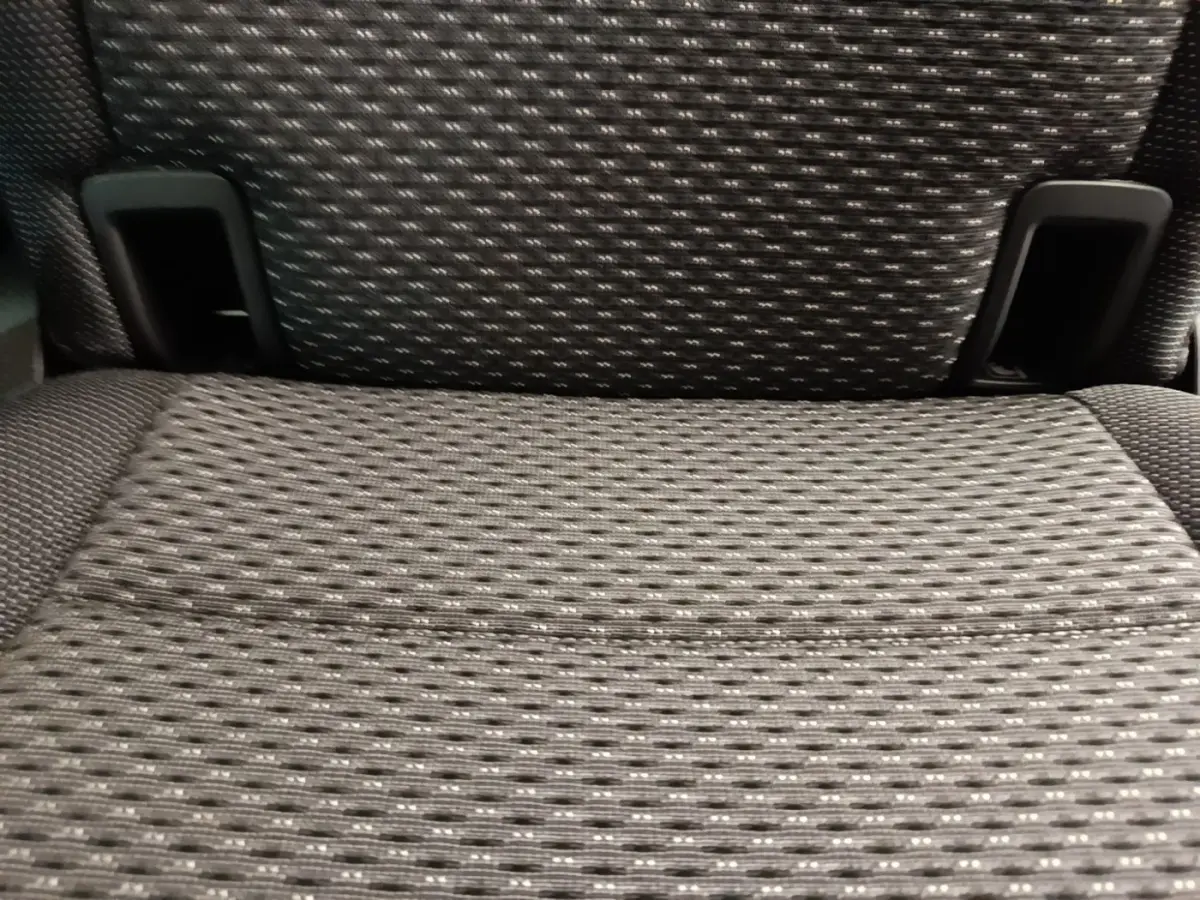 Gros plan sur l'assise en tissu gris foncé d'un siège arrière individuel du Volkswagen Touran 2024.