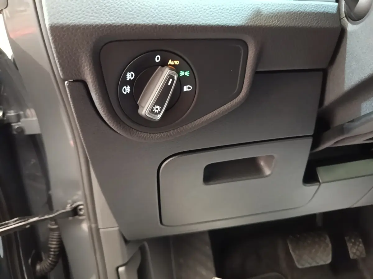 Détail intérieur du tableau de bord côté conducteur du Volkswagen Touran 2024 avec commande des phares.