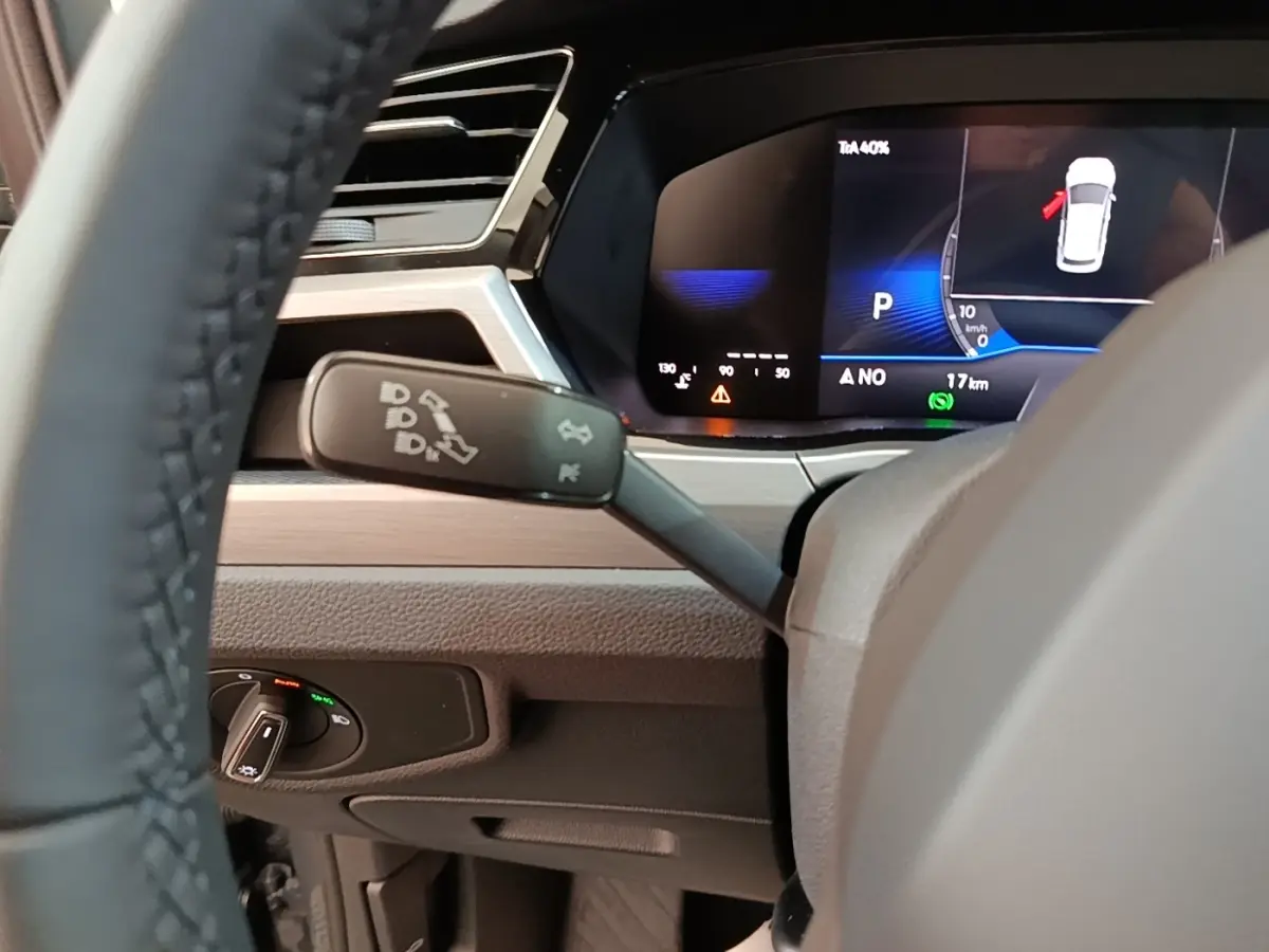 Gros plan sur le combiné d'instruments digital du Volkswagen Touran 2024 avec affichage multifonctions et commandes au volant.