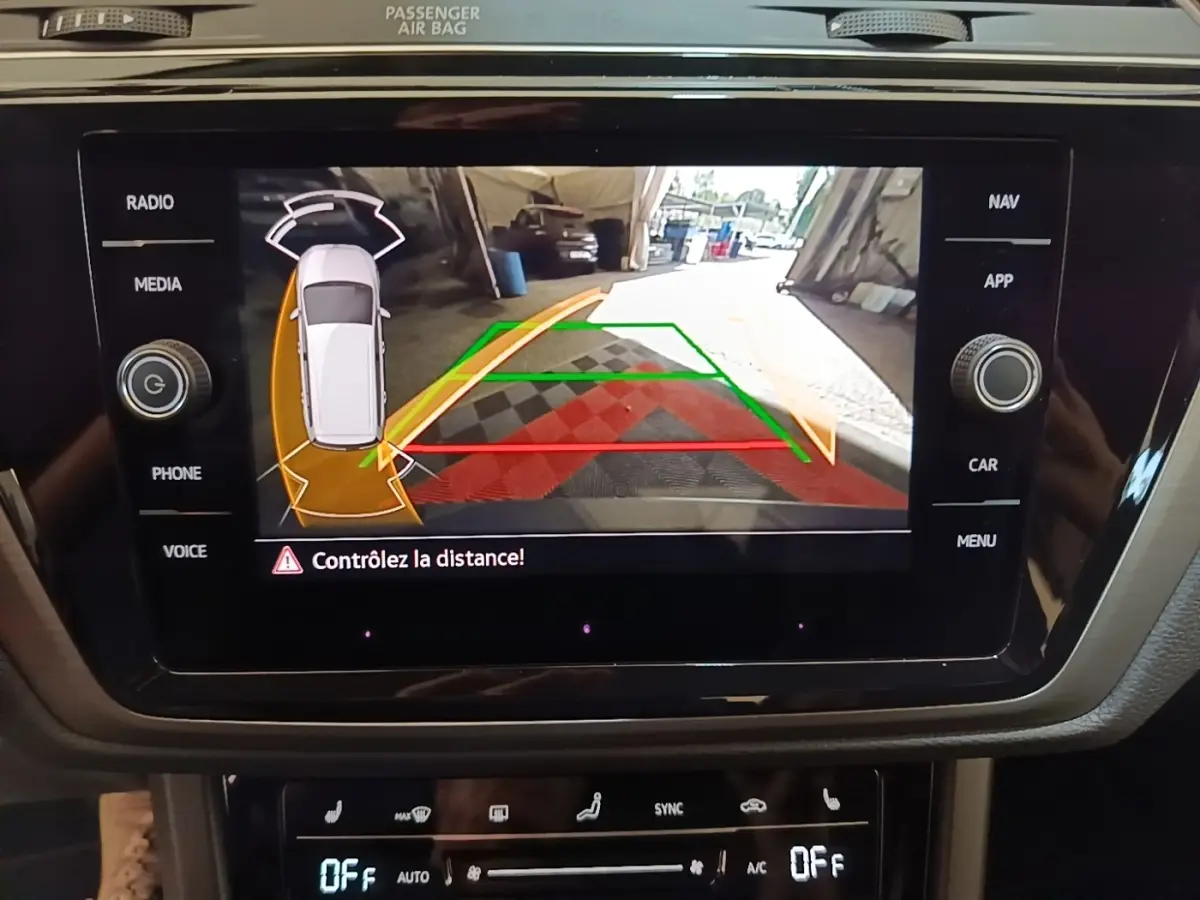 Écran tactile central affichant la caméra de recul avec guidage, dans un Volkswagen Touran gris clair 2024.